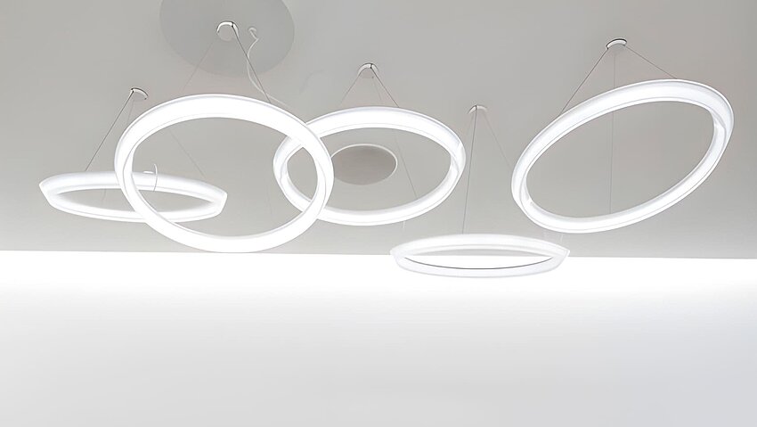 Decke mit hängenden überlappenden LED-Lichtringen in Weiß