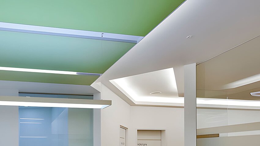 Praxisdecke mit grünem Deckensegel und hängenden Lichtbändern