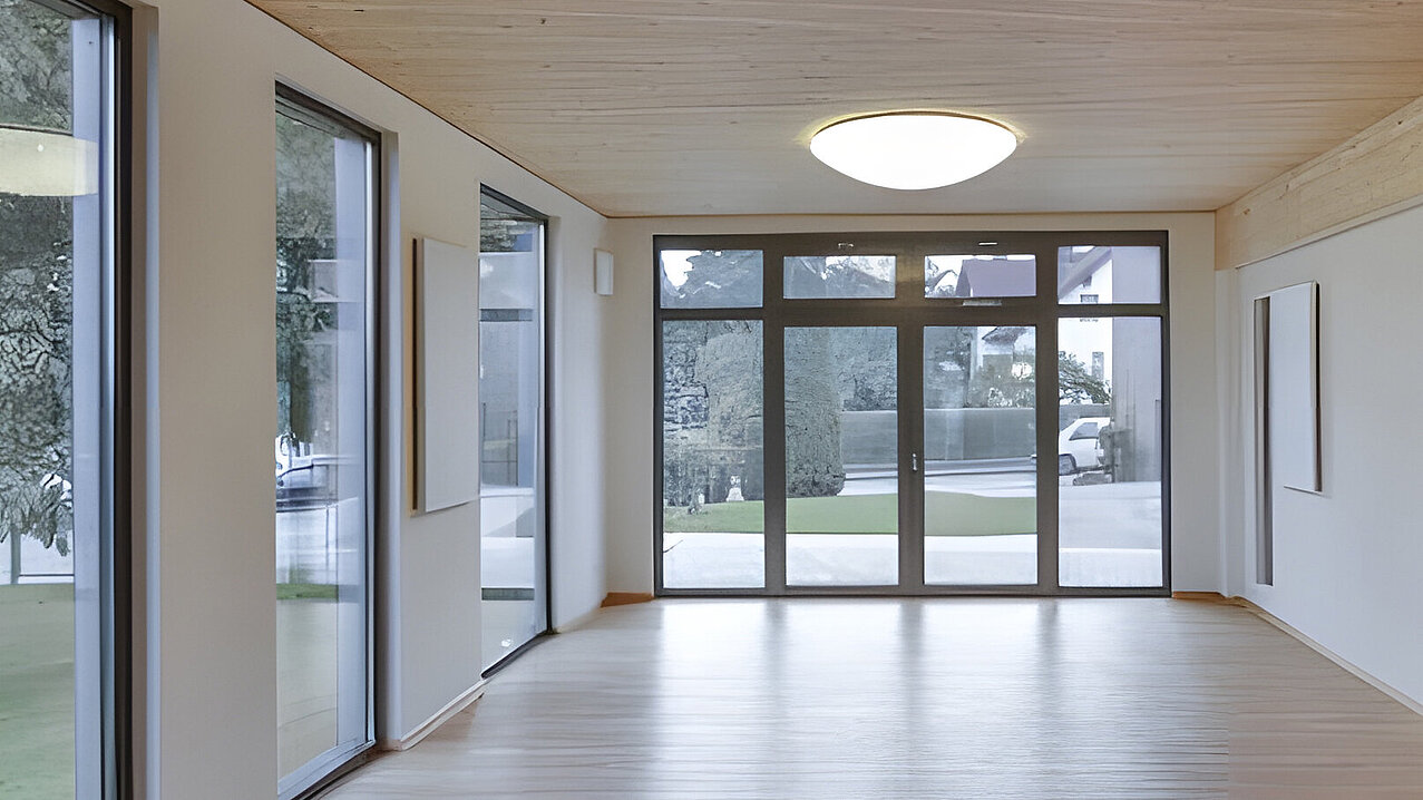 Heller leerer Innenraum mit großen Fensterfronten Holzdecke und Deckenleuchte